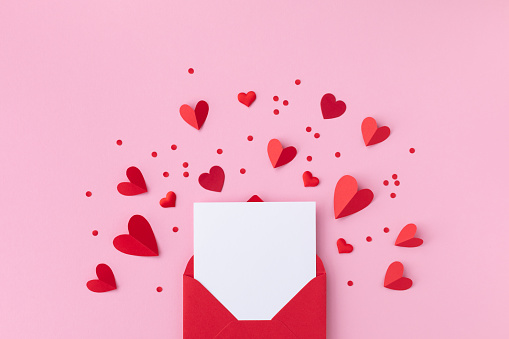 San Valentín día de San Valentín de fondo con sobre, tarjeta de papel y varios corazones rojos para el amor romántico mensaje plano laico. photo