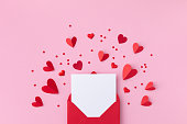 聖バレンタインデーの休日の背景に封筒、紙のカード、愛のロマンチックなメッセージ用のさまざまな赤いハート。