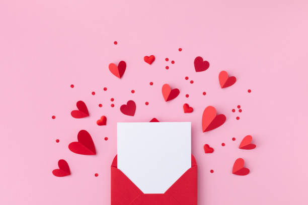 Saint Valentine day holiday background with envelope, paper card and various red hearts for love romantic message flat lay.