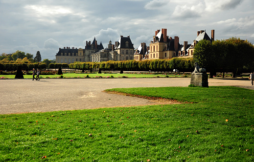 Paris, France – October 18, 2010: A beautiful view of tourists enjoying the gardens of Fontainebleau Palace in Paris, France