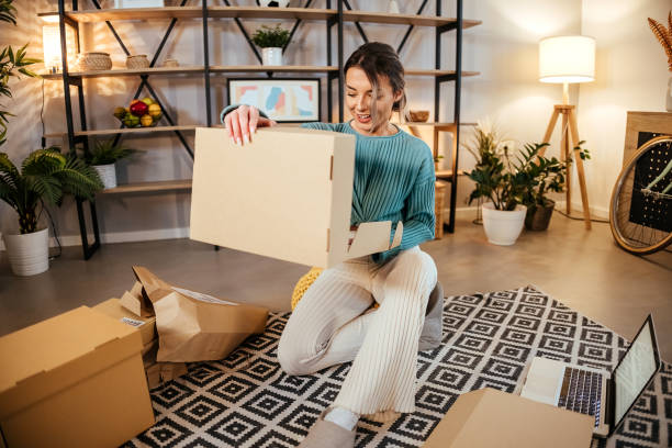 Satisfied young woman opening a postal delivery stock photo