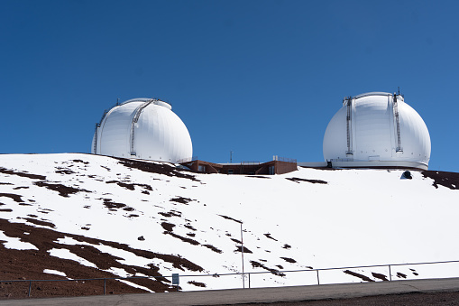 Island of Hawaii, United States – January 04, 2022: The NASA Observatory at the Mauna Kea snowy mountain against a clear blue sky on a cold winter day