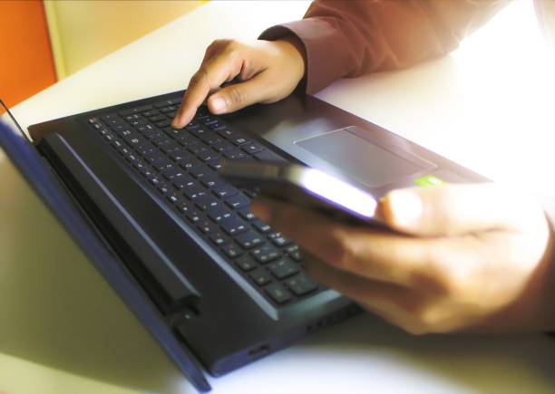 istock Hands using laptop and smartphone for online shopping with daytime soft light shining high contrast 1454842489