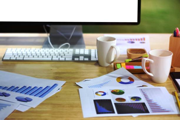 istock Wooden desk table office with big computer screen and coffee cup 1454842803