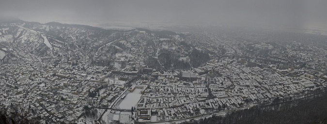 An aerial view of houses in a town during a foggy winter day