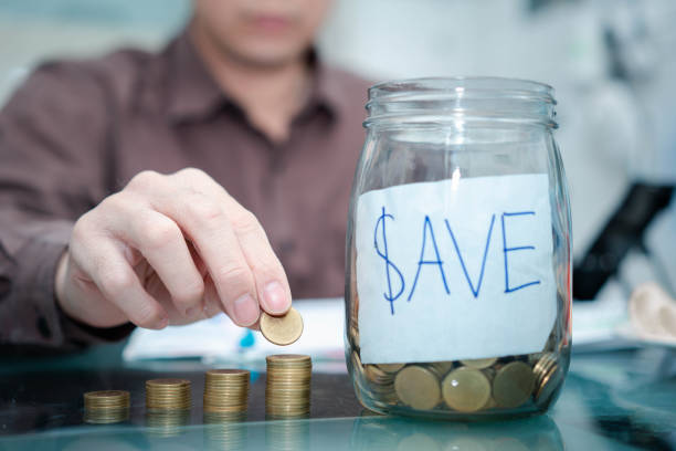 istock businessman divide coins in saving management in jar and stack coin 1454845413