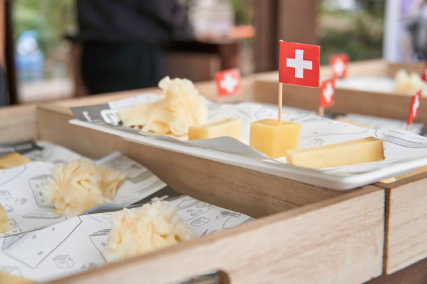 vassoio con mix di formaggi svizzeri e bandiera svizzera. gruviera, emmental, tete de moine e tilsiter - cheese tray cube swiss cheese foto e immagini stock