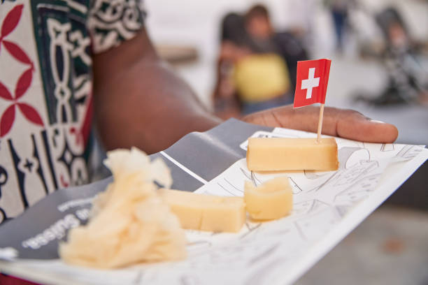 taca z mieszanką serów szwajcarskich i flagą szwajcarii, trzymana przez czarnoskórego mężczyznę - cheese tray cube swiss cheese zdjęcia i obrazy z banku zdjęć