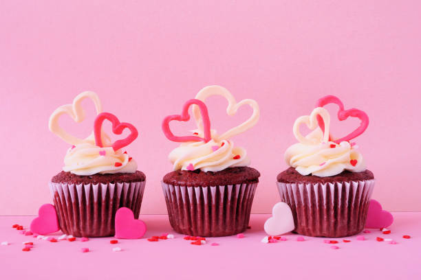 Valentines Day theme red velvet cupcakes with a pink background