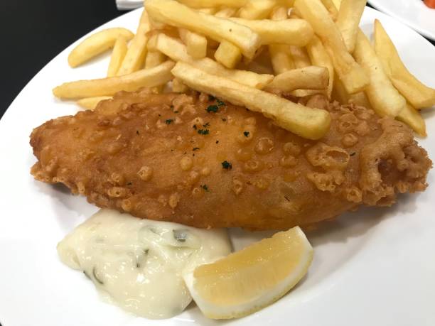 ryba z frytkami (smażona ryba, frytki, sos tatarski i cytryna) na białym talerzu - fish and chips cafe restaurant salad zdjęcia i obrazy z banku zdjęć