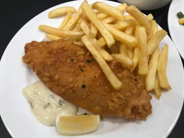 ryba z frytkami (smażona ryba, frytki, sos tatarski i cytryna) na białym talerzu - fish and chips cafe restaurant salad zdjęcia i obrazy z banku zdjęć