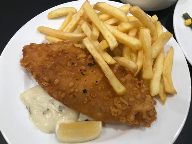 ryba z frytkami (smażona ryba, frytki, sos tatarski i cytryna) na białym talerzu - fish and chips cafe restaurant salad zdjęcia i obrazy z banku zdjęć