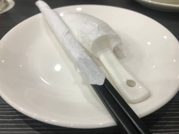 istock white spoon and black chopsticks covered in paper towels on a white plate 1454847207