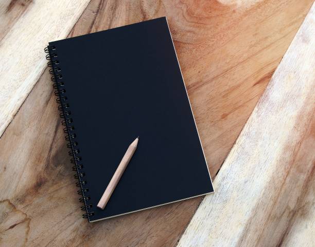 istock notebook and pencil on old wood table 1454847942
