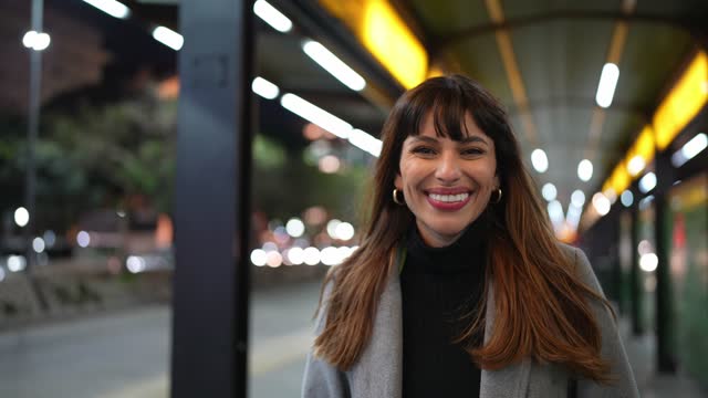 Portrait of a young woman smiling on bus station