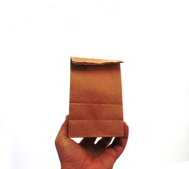 istock hand holding a brown paper bag 1454851627