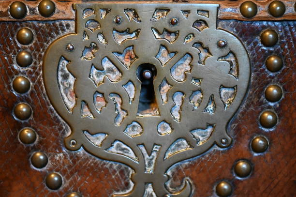 Antique key hole Tarnished silver coloured key hole on an old wooden chest in Kent metal stud stock pictures, royalty-free photos & images