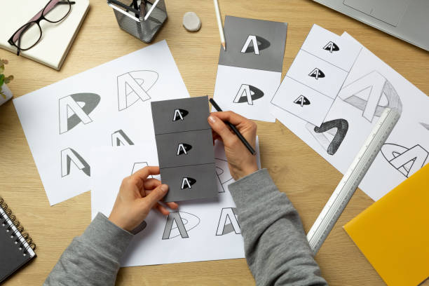 istock A graphic designer develops a logo for a brand. The illustrator draws sketches on paper. 1454854250