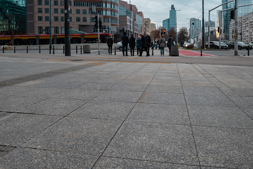Warsaw, Poland- 01.02.2023: The sidewalk is paved with granite tiles against the background of a pedestrian crossing.
