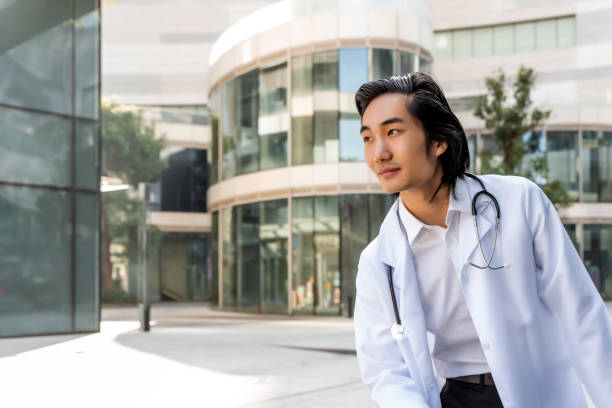 istock Male doctor looking thoughtful outdoors. 1454858519