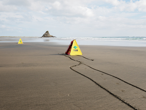 Auckland, New Zealand – February 13, 2022: View of surf lifeguard life savers at Karekare beach. Lafesaving club. TSB bank sign.