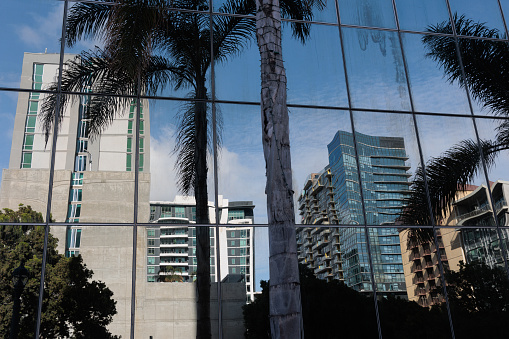The buildings of downtown San Diego reflected in the glass of an office tower