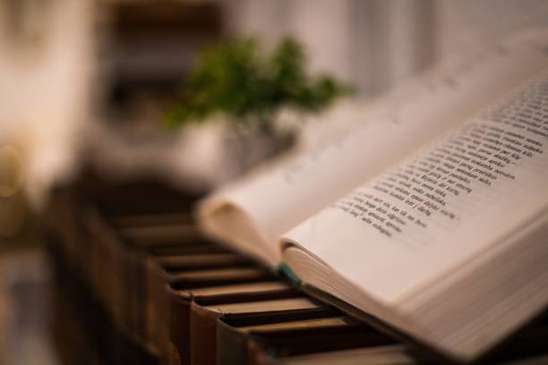 istock Bible opened on old books plased on a wooden commode 1454862247