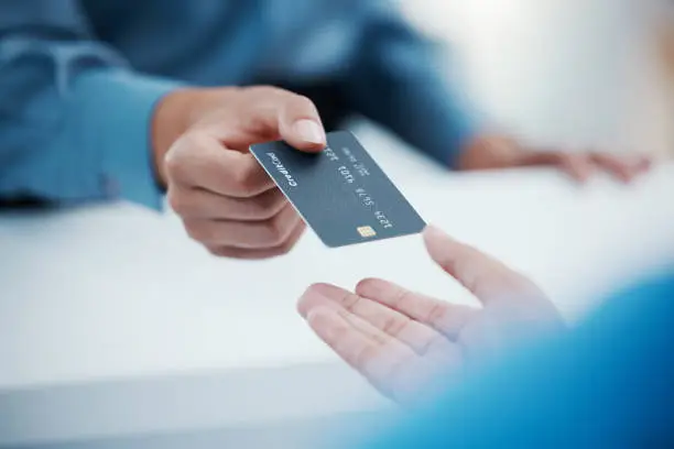 Photo of Corporate hands exchange credit card to accountant for payment for company tax bills, money loan and accounting fees. Businessman with banking card to invest in financial savings budget investment