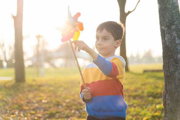 istock boy having fun with weather vane toy in the park 1454862474