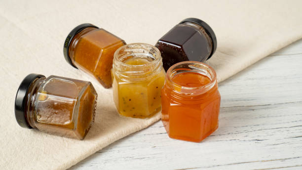 istock Mini jam jars. Tiny jars of jam. Different fruit jams in glass bottles 1454864256