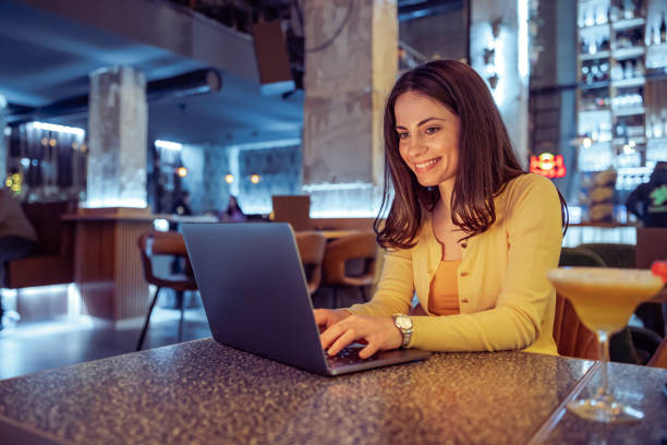 istock Young woman using laptop at cafe 1454864509