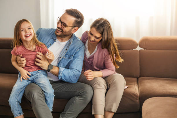 istock Cheerful mom, dad and daughter having fun together at home 1454866542