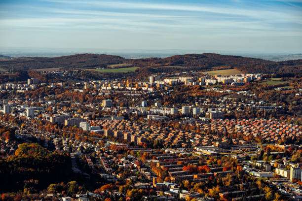 istock Beautiful shot buildings surrounded with trees and mountains in the back 1454866616