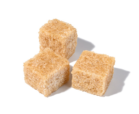 Cane sugar cubes on white background, top view