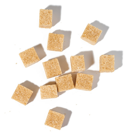 Cane sugar cubes on white background, top view