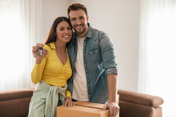 istock Smiling couple unpacking boxes in new home 1454867901