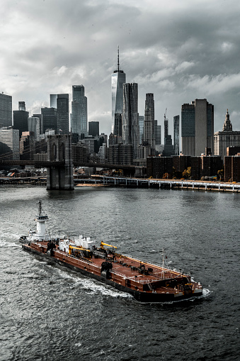 An amazing moment with cloudy sky,  the whole Lower Manhattan and the Brooklyn Bridge captured from the Manhattan Bridge in New York during an autumn afternoon.