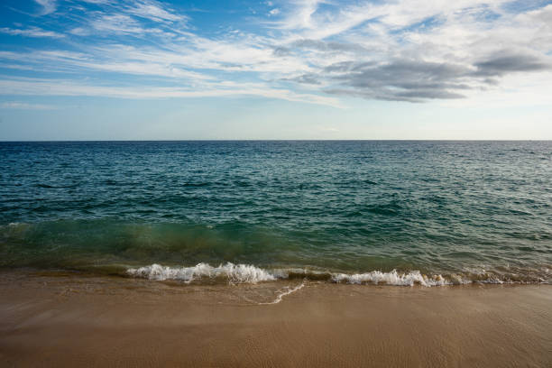 Beach with Tide Rolling In Under Cloudscape in Cabo San Lucas Mexico on a Sunny Afternoon