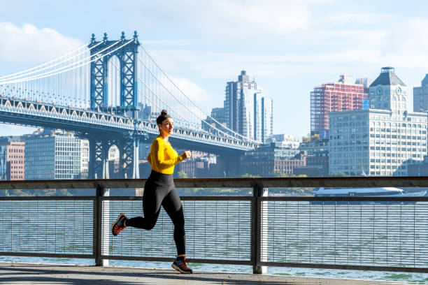 красивая женщина наслаждается фитнесом в нью-йорке - east river audio стоковые фото и изображения