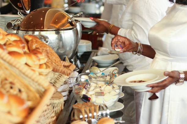 istock Restaurant kitchen with chefs preparing food behind a table with bread and buns in baskets 1454869493