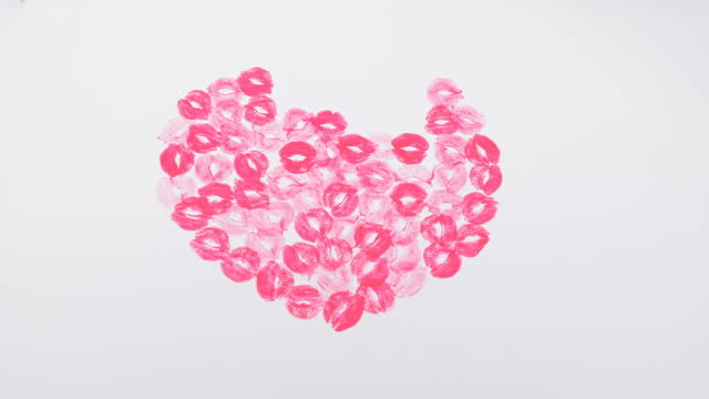 Big pink heart made of kisses on a white paper background