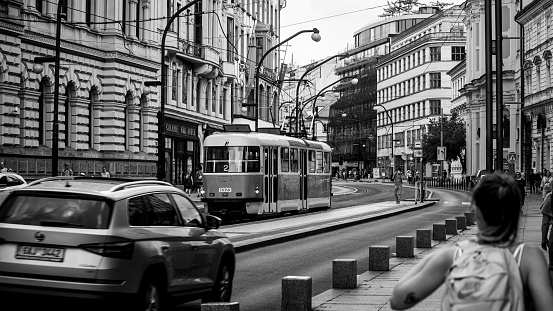 Prague, Czech Republic – August 04, 2021: A grayscale shot of people walking in a busy street with different buildings in Prague, Czech Republic