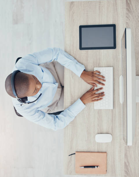 istock Customer service black man, computer or CRM employee working for research, contact us or networking with headphones. Telemarketing, telecom or sales advisor for consulting, help or customer support 1454872734