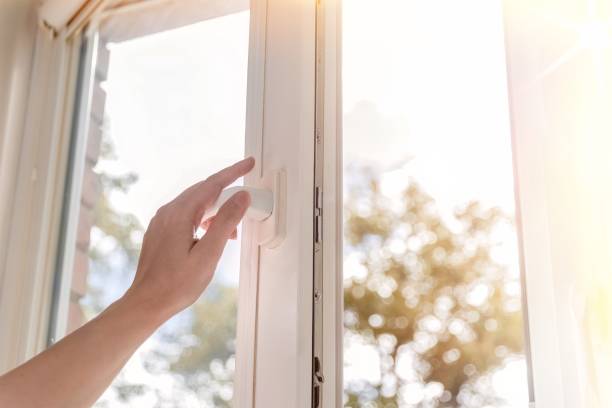 istock woman hand open white plastic window with sunny background. 1454874860