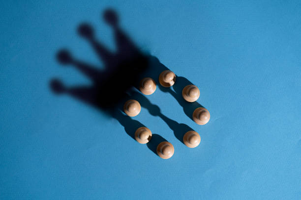 abstract concept, chess pawns make a shadow of queen or king crown