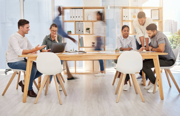 istock Busy office, team and coworking employee group planning a digital strategy at a desk. Teamwork, collaboration and online marketing workforce with technology speaking about a advertising web schedule 1454881080