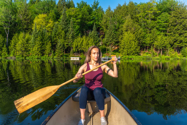 Close up shot of a kayak near shore in shallow water, reflecting sunlight. Shot in lake at Algonquin Provincial Park, Ontario Canada