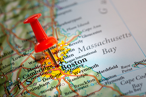 A push pin on a map of North America marking the location of the city of Boston