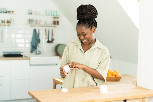istock Smiling young women applying moisturizer 1454889172