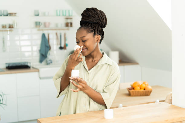 istock Smiling young women applying moisturizer 1454889177